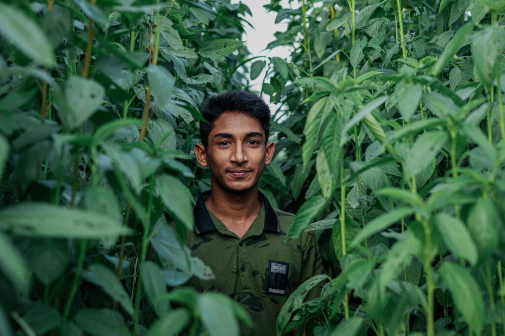Why the Social Business Model Makes Sense: As of 2024, Bangladesh remains a largely agricultural country, with over 75% of the land mass and 50% of the workforce engaged in agriculture. Pic: a man amongst plants. 
